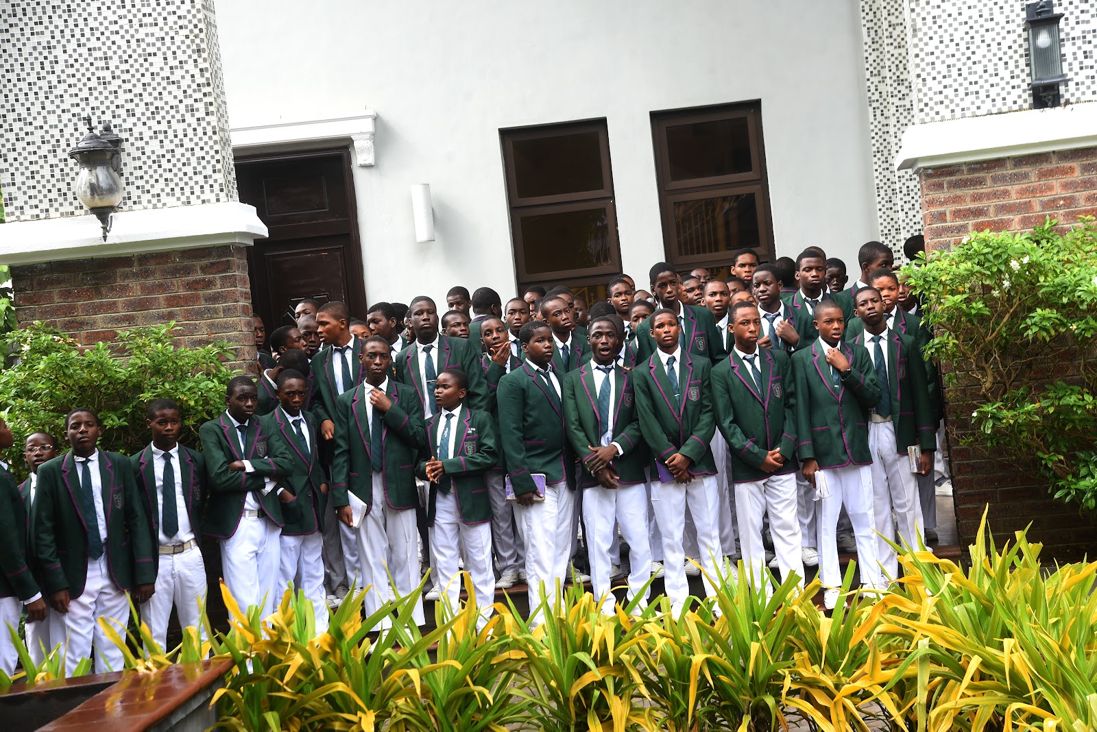 Students in green blazers assembled together in the College grounds