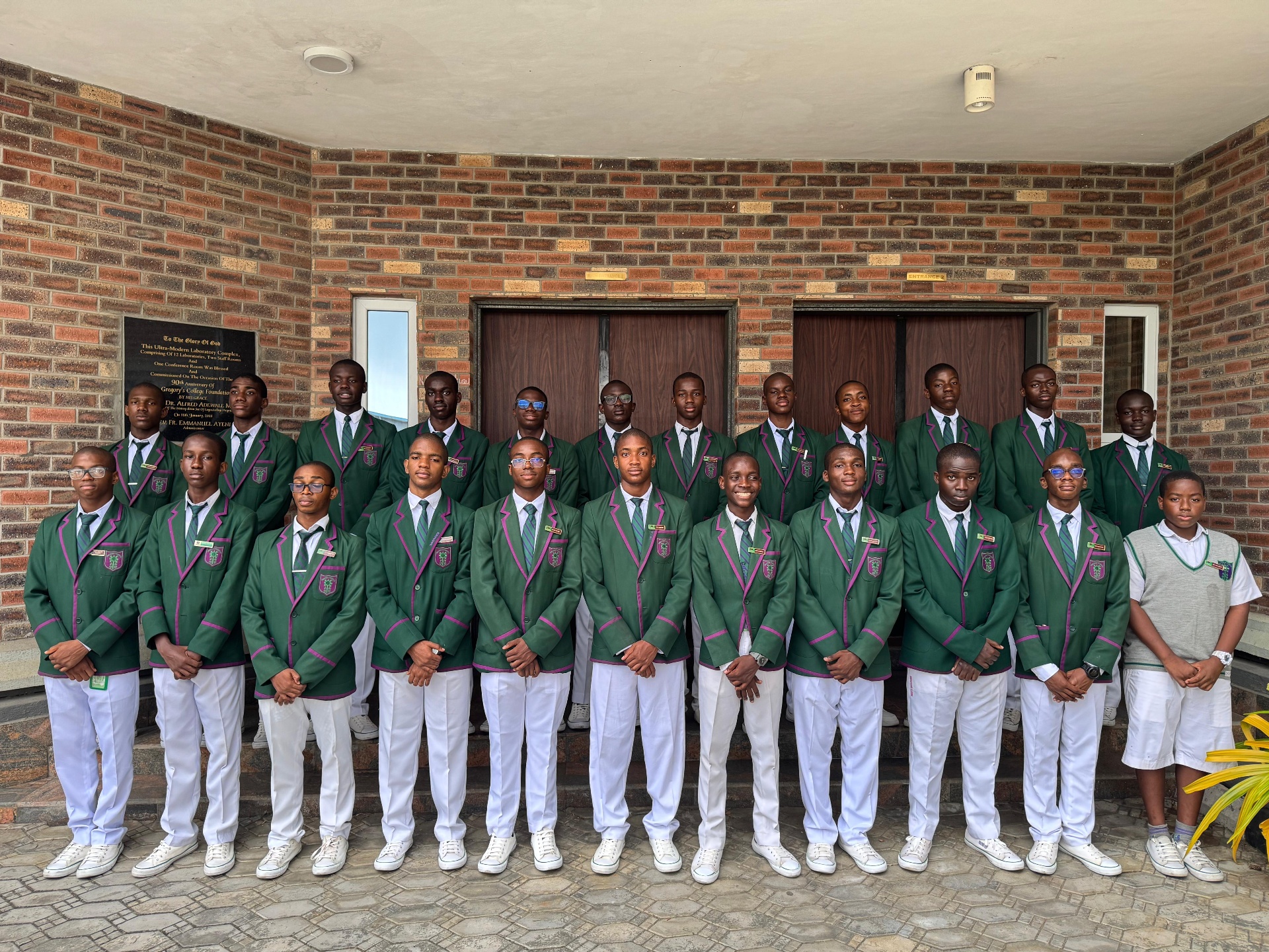 A group of Saint Gregory's College students in green blazers gathered outside the College laboratory complex