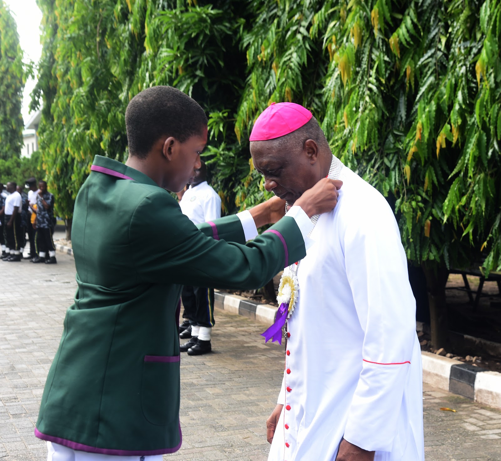 A student greeting a visiting member of the clergy