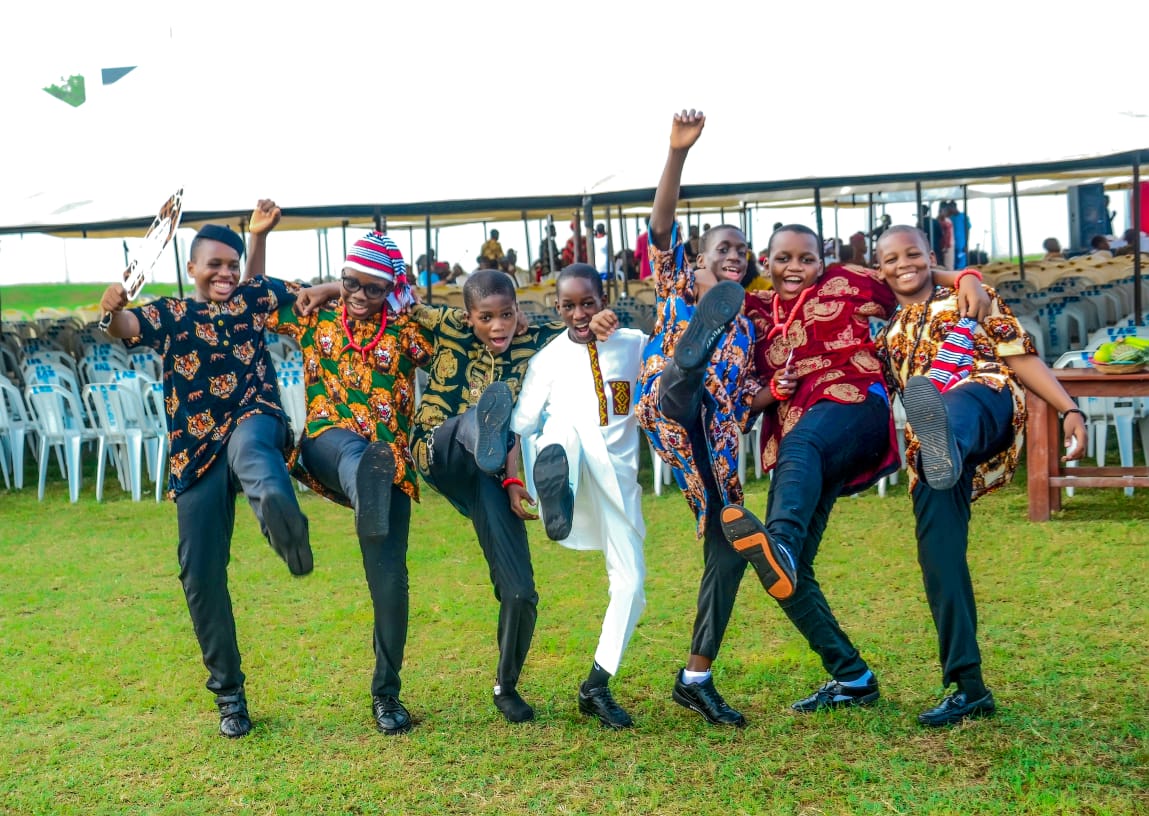 Students in traditional attire celebrating together on the field