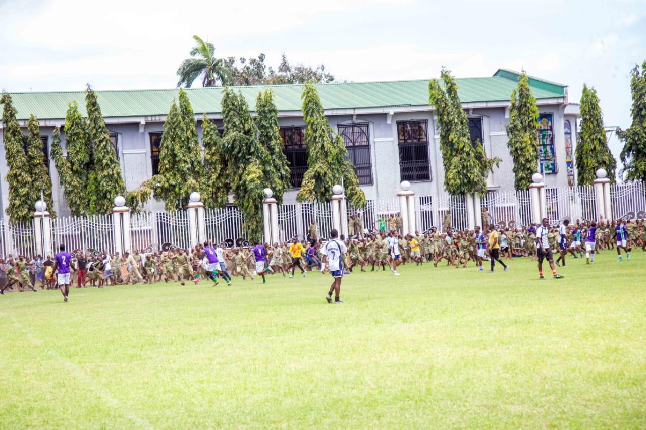 Students streaming onto the field in front of the College chapel
