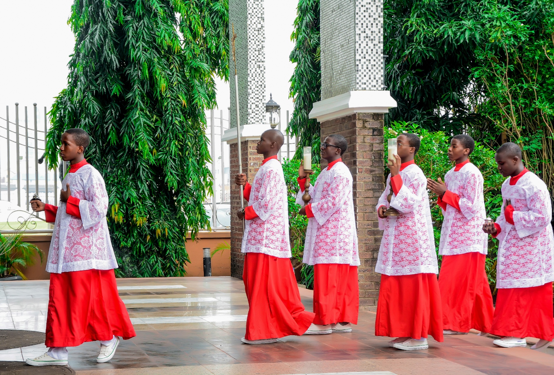 Altar servers in red and white vestments processing at a College liturgy